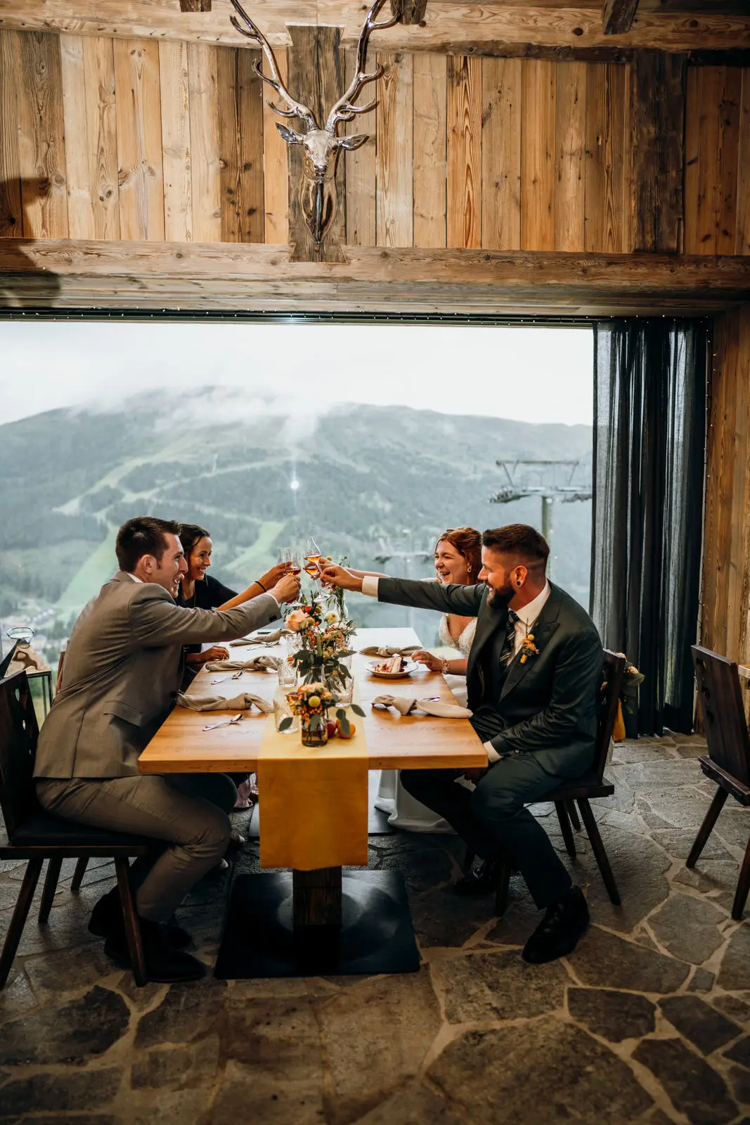 Hochzeit am Katschberg mit einem Tisch für 4 Personen vor einem großen Panoramafenster mit Blick auf die Berge.