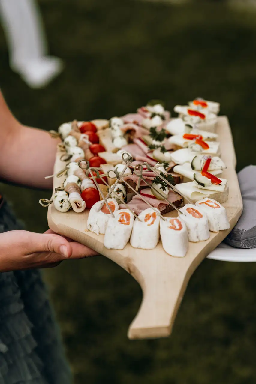 Rustikales Fingerfood auf einem Holzbrett bei einer standesamtlichen Hochzeit auf der Alm