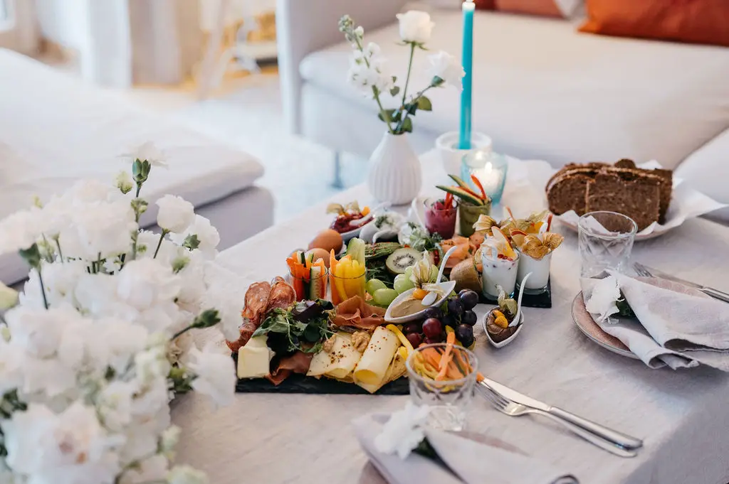 Ein liebevoll arrangiertes Hochzeitsfrühstück mit frischen Früchten, Käse, Brot und edler Tischdekoration – der perfekte Start in den Hochzeitstag beim Elopement am Tegernsee.