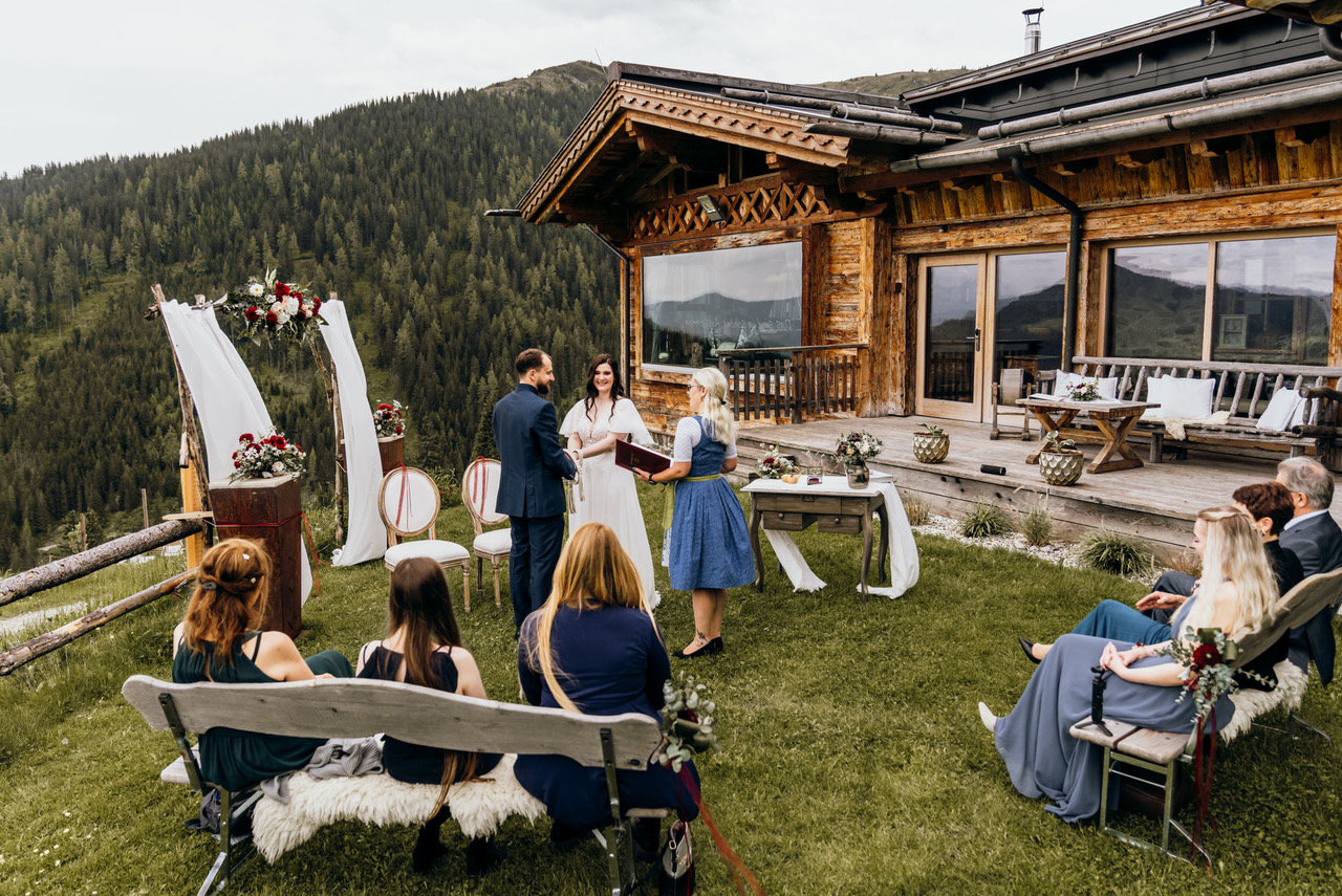 Standesamtliche Trauung im kleinen Kreis vor einer rustikalen Berghütte mit Blick ins Tal