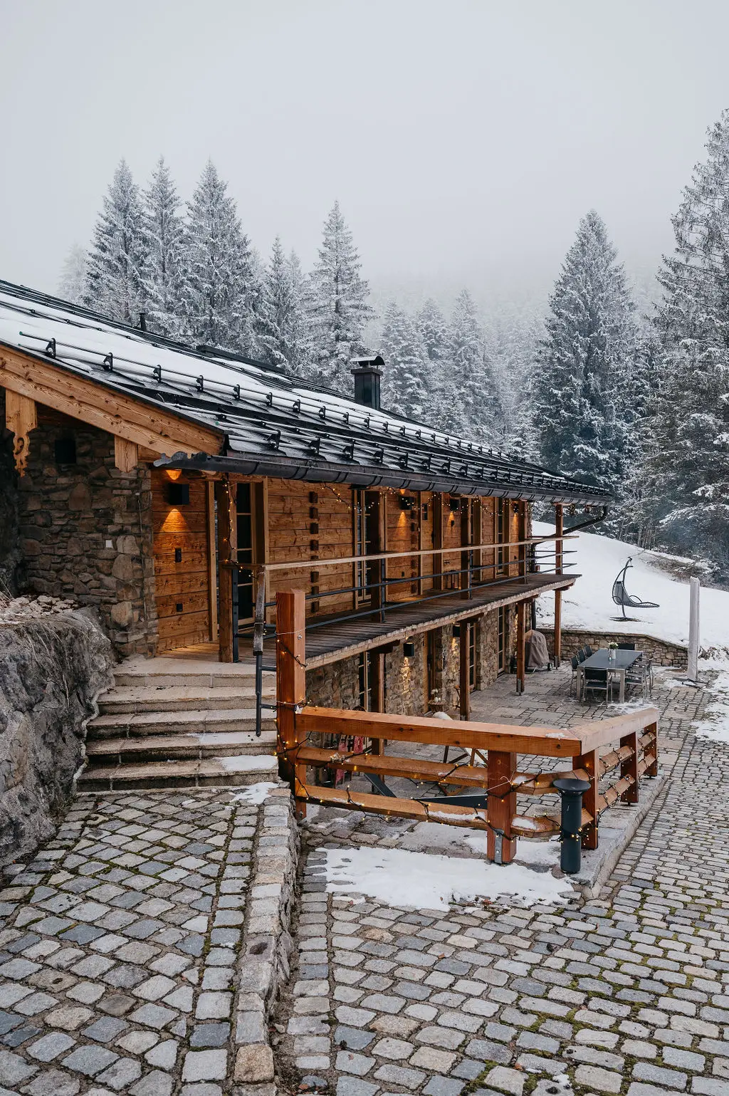 Eine rustikale Berghütte umgeben von verschneiten Tannen – die perfekte Location für eine romantische Winterhochzeit oder ein Elopement am Tegernsee.
